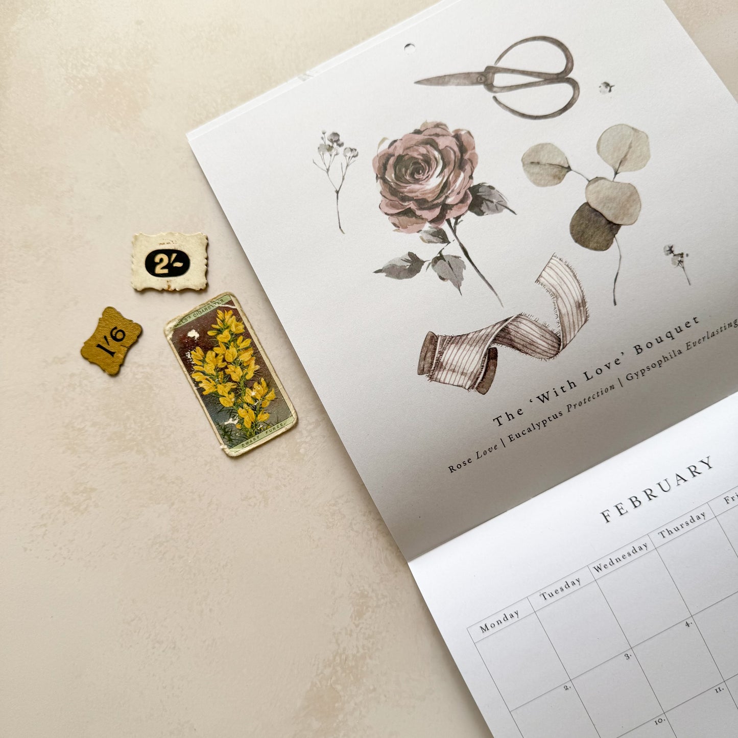 Floral design on a calendar and decorative items on a beige surface