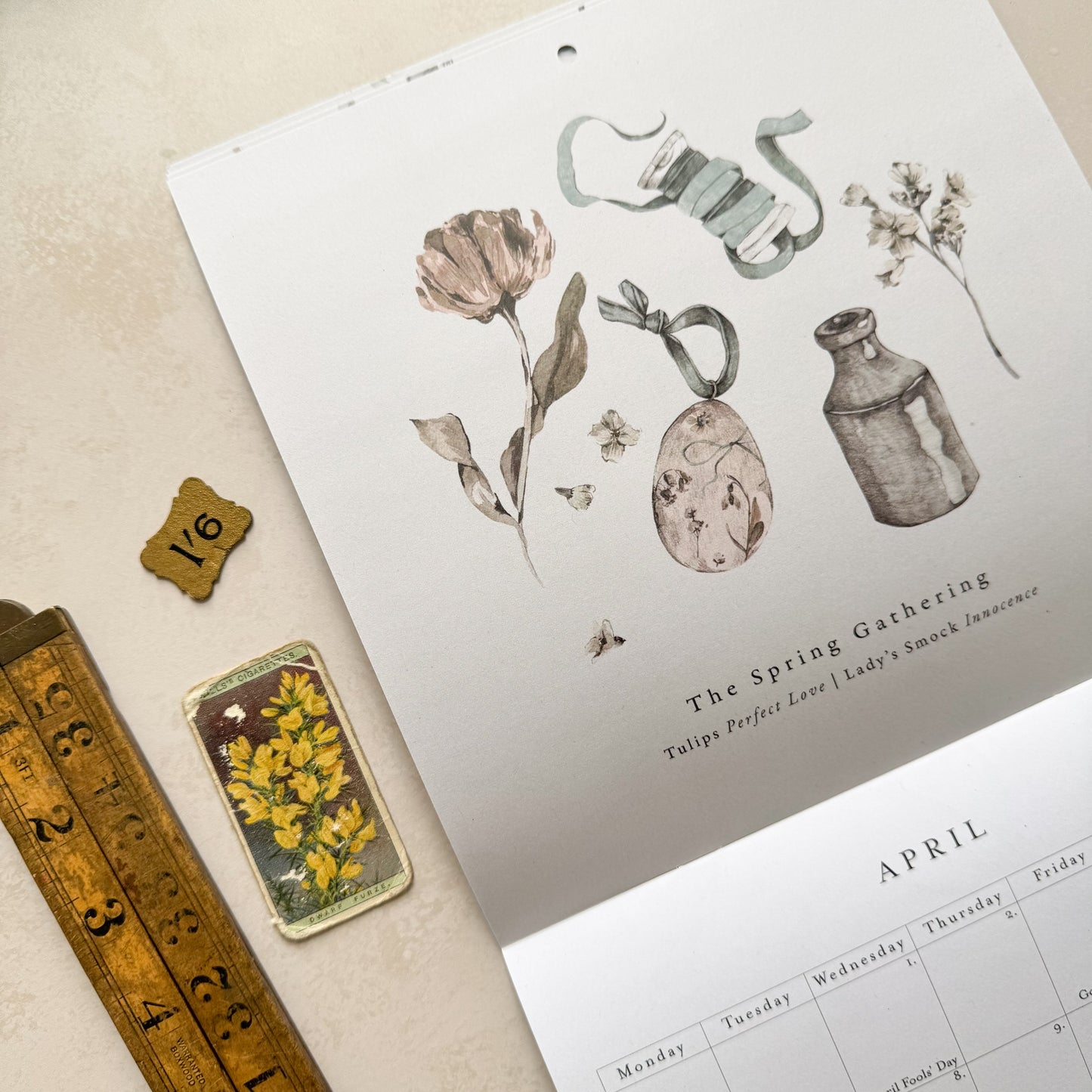 Botanical illustrations and a calendar on a beige surface.