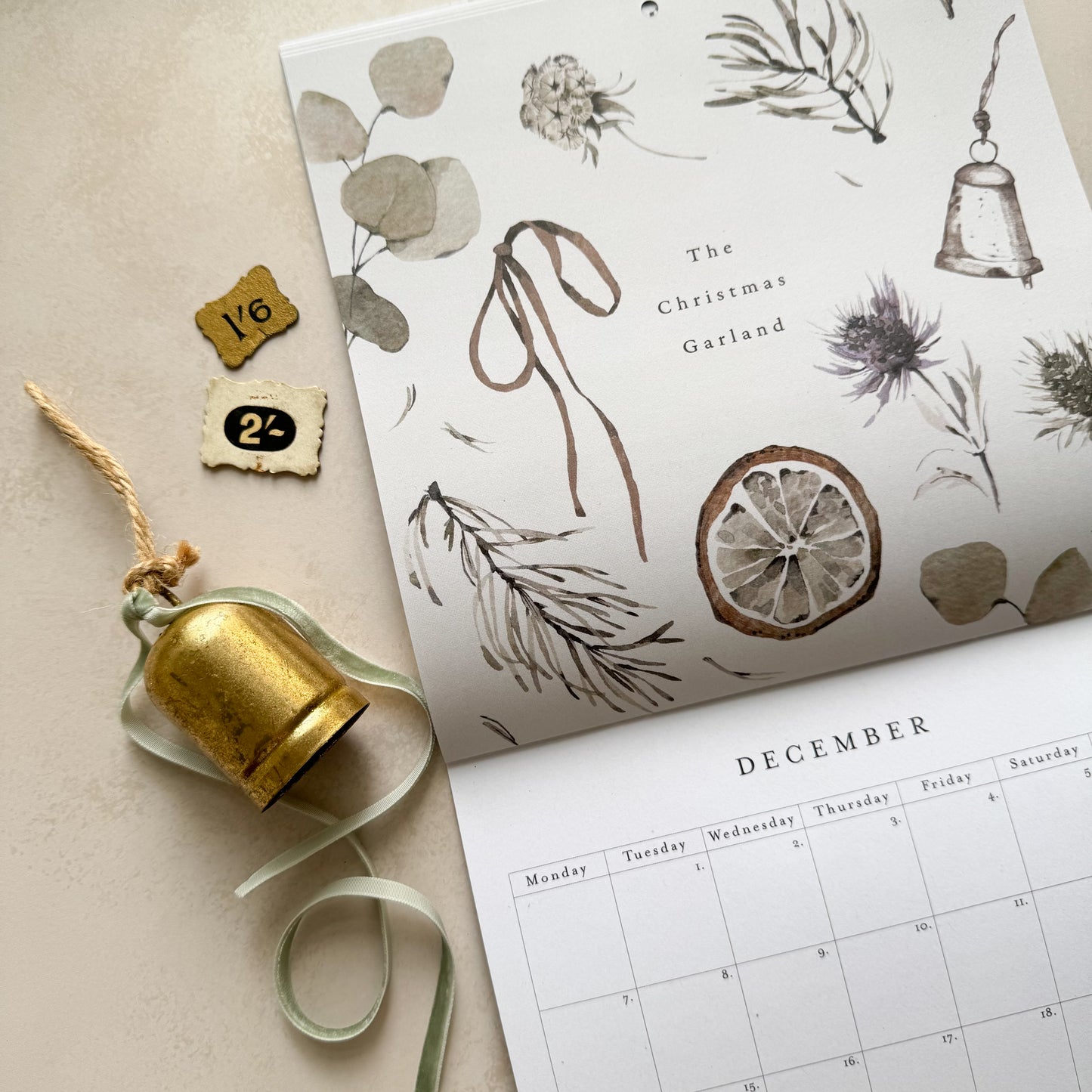 Calendar with Christmas-themed design and decorative elements on a beige surface