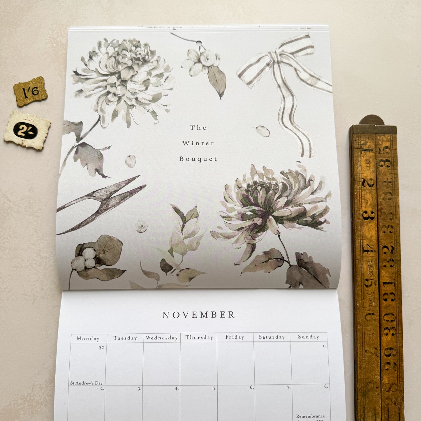 Calendar with floral design and measurement tool on a beige background
